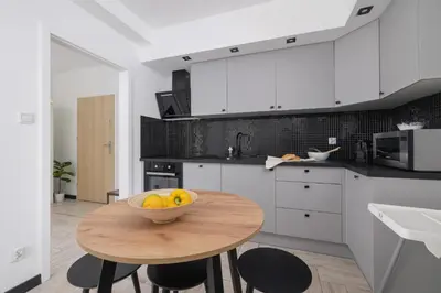 a kitchen with a bowl of fruit on a wooden table at Eklsuzywny Apartament z Parkingiem w Krakowie by Renters Prestige in Kraków