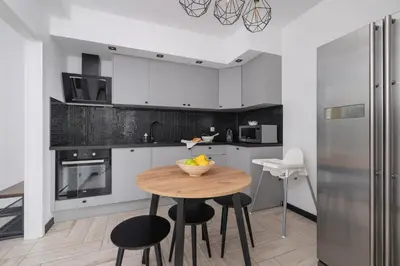 a kitchen with a table and chairs and a refrigerator at Eklsuzywny Apartament z Parkingiem w Krakowie by Renters Prestige in Kraków