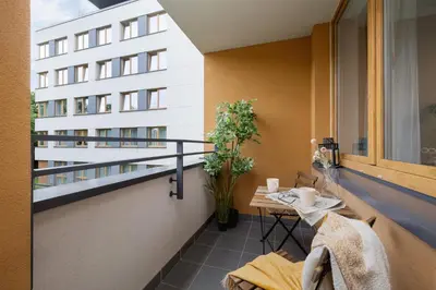 a balcony with a table and a building at Eklsuzywny Apartament z Parkingiem w Krakowie by Renters Prestige in Kraków