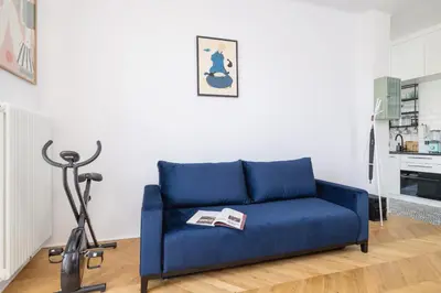 a blue couch in a living room with a treadmill at Kraków Apartament Blisko Centrum Kongresowego i Wawelu by Noclegi Renters in Kraków