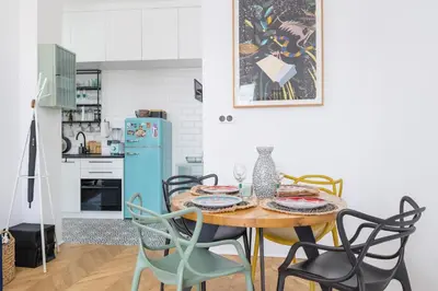 a dining room table with chairs and a blue refrigerator at Kraków Apartament Blisko Centrum Kongresowego i Wawelu by Noclegi Renters in Kraków