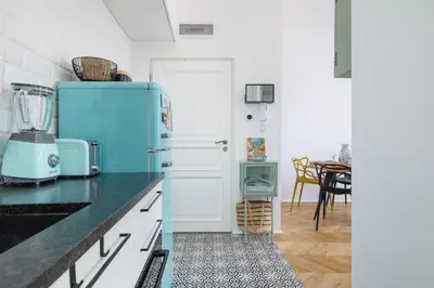 a kitchen with a blue refrigerator and a dining room at Kraków Apartament Blisko Centrum Kongresowego i Wawelu by Noclegi Renters in Kraków