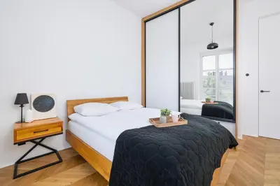 a bedroom with a bed with a table and a mirror at Kraków Apartament Blisko Centrum Kongresowego i Wawelu by Noclegi Renters in Kraków