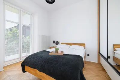 a bedroom with a bed and a large window at Kraków Apartament Blisko Centrum Kongresowego i Wawelu by Noclegi Renters in Kraków