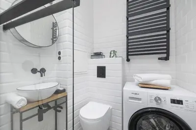 a bathroom with a sink and a washing machine at Kraków Apartament Blisko Centrum Kongresowego i Wawelu by Noclegi Renters in Kraków