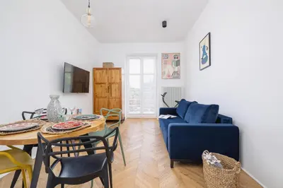 a living room with a table and a blue couch at Kraków Apartament Blisko Centrum Kongresowego i Wawelu by Noclegi Renters in Kraków