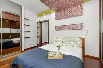 a bedroom with a blue bed and a mirror at Gamers' Paradise - Modern Apartment with Parking in Cracow by Noclegi Renters in Kraków