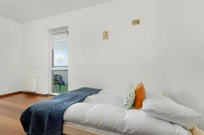 a bed with white sheets and pillows in a room at Gamers' Paradise - Modern Apartment with Parking in Cracow by Noclegi Renters in Kraków
