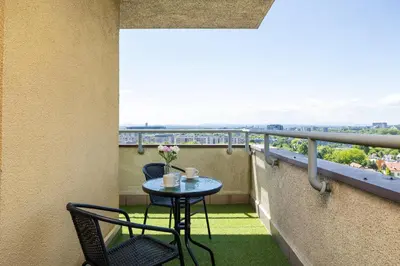 a table and chairs on a balcony with a view at Gamers' Paradise - Modern Apartment with Parking in Cracow by Noclegi Renters in Kraków