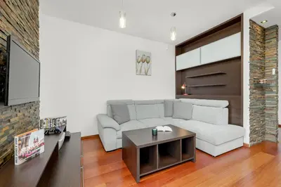 a living room with a white couch and a table at Gamers' Paradise - Modern Apartment with Parking in Cracow by Noclegi Renters in Kraków