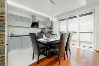 a kitchen and dining room with a table and chairs at Gamers' Paradise - Modern Apartment with Parking in Cracow by Noclegi Renters in Kraków