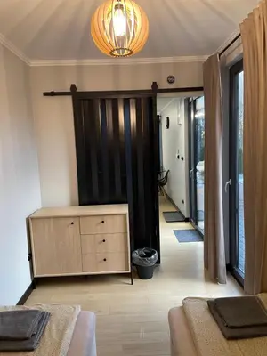 a living room with a dresser and a sliding door at Kontener 15G in Skawina