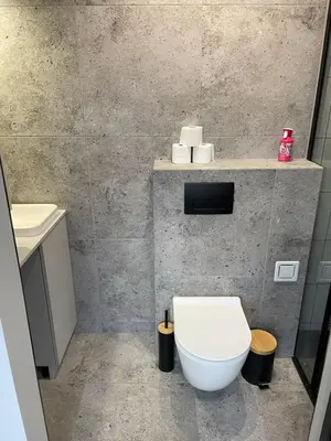 a bathroom with a white toilet and a sink at Kontener 15G in Skawina