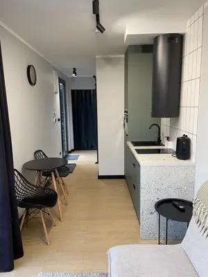 a kitchen with chairs and tables and a counter at Kontener 15G in Skawina