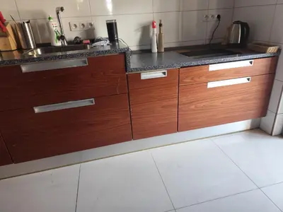 a kitchen with wooden cabinets and a sink at Apartament Deluxe w centrum Brzeska nr 2 in Brzesko