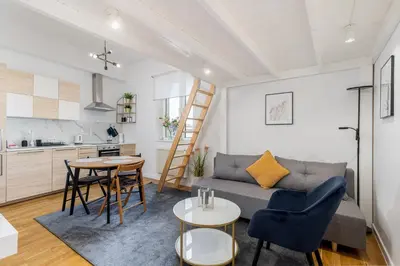 a living room with a couch and a table at Old Town Chic Studio with Mezzanine by BookingHost in Kraków