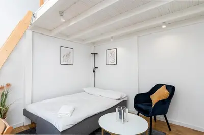 a bedroom with a bed and a chair and a table at Old Town Chic Studio with Mezzanine by BookingHost in Kraków