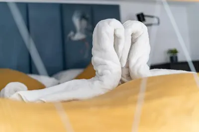 a person laying in a bed with white towels at Old Town Chic Studio with Mezzanine by BookingHost in Kraków
