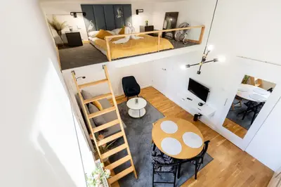 a room with a bed and a desk and a table at Old Town Chic Studio with Mezzanine by BookingHost in Kraków