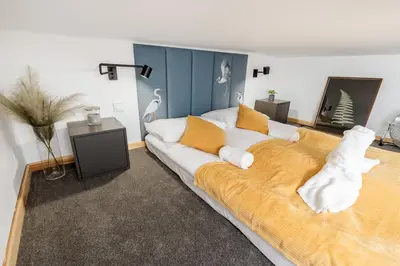 a bedroom with a large bed with white and orange pillows at Old Town Chic Studio with Mezzanine by BookingHost in Kraków
