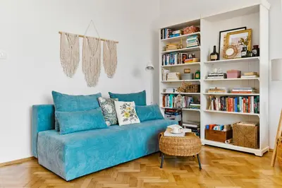 a blue couch in a living room with a book shelf at Funky Flat Krakow in Kraków