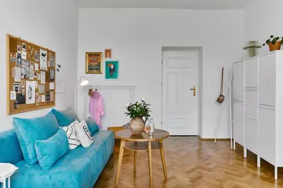 a living room with a blue couch and a table at Funky Flat Krakow in Kraków