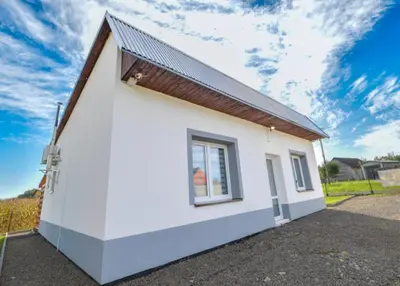 a white house with a window on the side of it at Dom z jacuzzi & tarasem całoroczny do 10 osób DOM NA PROMOWEJ - LAS, Zator in Zator