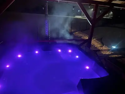 a hot tub with purple lights in a dark room at Dom z jacuzzi & tarasem całoroczny do 10 osób DOM NA PROMOWEJ - LAS, Zator in Zator