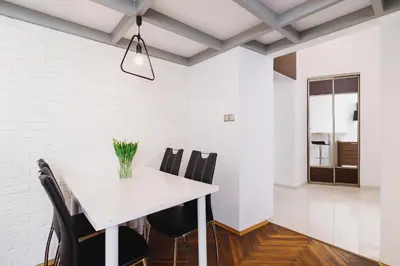a dining room with a white table and black chairs at Kazimierz - 34 Dietla street in Kraków