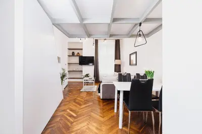 a dining room and living room with a table and chairs at Kazimierz - 34 Dietla street in Kraków