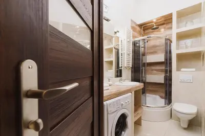 a bathroom with a toilet sink and a washing machine at Kazimierz - 34 Dietla street in Kraków