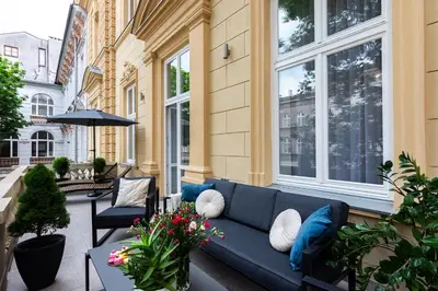 a patio with a blue couch and some plants at Old Town K34 by M Apartments in Kraków