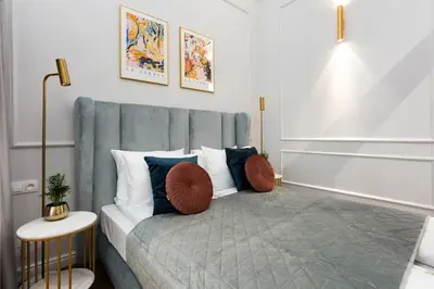a bedroom with a blue couch with pillows on it at Old Town K34 by M Apartments in Kraków