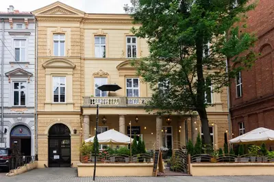 a building with tables and umbrellas in front of it at Old Town K34 by M Apartments in Kraków