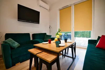 a living room with a table and a green couch at Dolce Vita by Housine in Zator