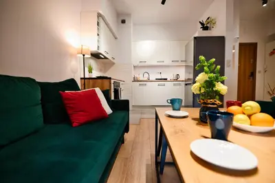 a living room with a green couch and a wooden table at Dolce Vita by Housine in Zator