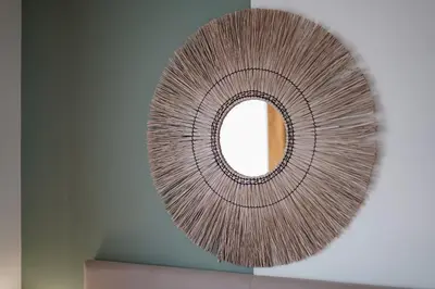 a circular mirror hanging on a wall at Saska Park Apartments in Kraków