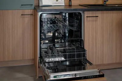 an open dishwasher with dishes in it in a kitchen at Saska Park Apartments in Kraków