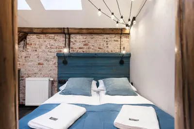 a bedroom with a bed with blue sheets and pillows at Kazimierz District - Dietla 51 street in Kraków