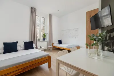 a bedroom with a bed and a living room at 3-bedroom apartment - 51 Dietla street in Kraków