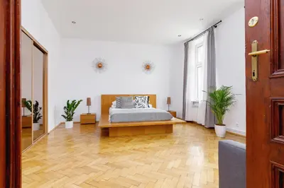 a bedroom with a bed and a wooden floor at Two Bedroom Apartment - Dietla 51 street in Kraków