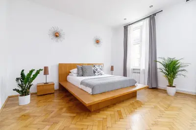 a bedroom with a bed and two potted plants at Two Bedroom Apartment - Dietla 51 street in Kraków