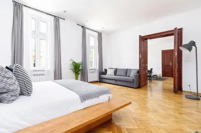 a white bedroom with a bed and a couch at Two Bedroom Apartment - Dietla 51 street in Kraków