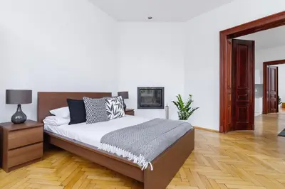 a bedroom with a large bed and a wooden floor at Two Bedroom Apartment - Dietla 51 street in Kraków