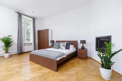 a bedroom with a bed and two potted plants at Two Bedroom Apartment - Dietla 51 street in Kraków