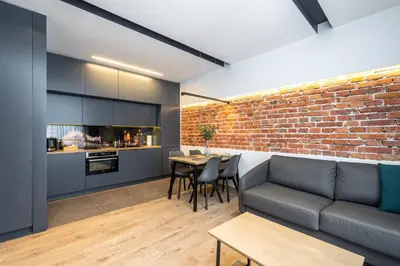 a living room with a couch and a brick wall at RentPlanet - Apartament Prusa in Kraków
