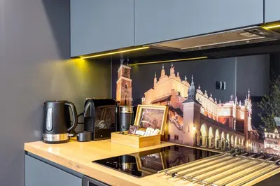 a kitchen with a painting of a building on the wall at RentPlanet - Apartament Prusa in Kraków