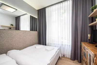 a bedroom with a bed and a large window at RentPlanet - Apartament Prusa in Kraków