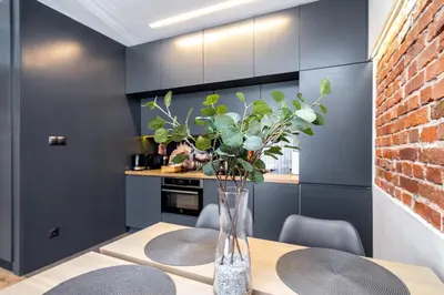 a dining room with a table with chairs and a brick wall at RentPlanet - Apartament Prusa in Kraków