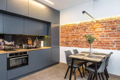 a kitchen with a dining table and a brick wall at RentPlanet - Apartament Prusa in Kraków